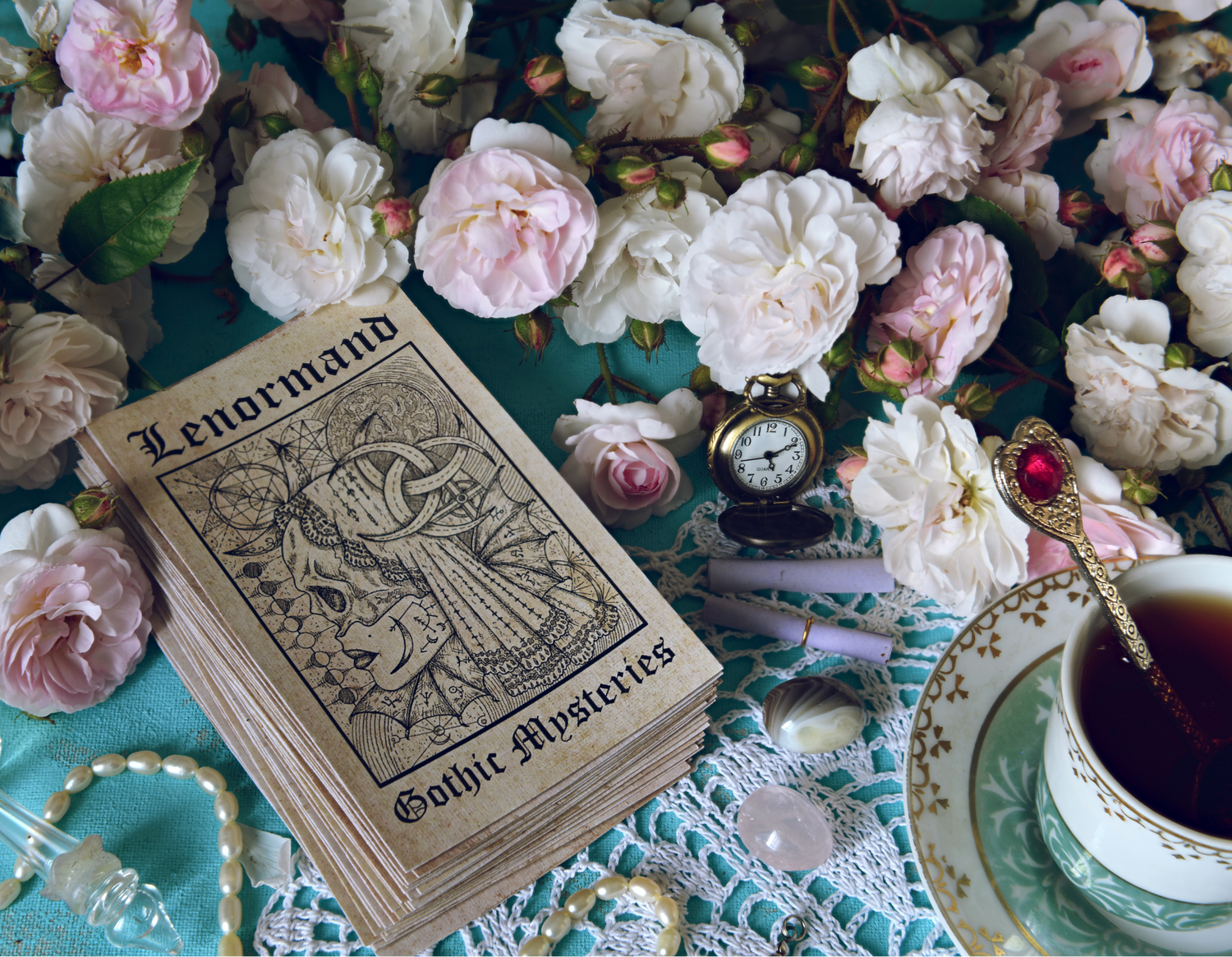 Lenormand card deck with flowers, a teacup, and decorative items on a textured surface.